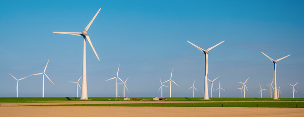 Drone Aerial view at Windmill park with windmills turbines in the ocean with a blue sky