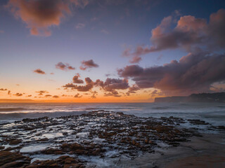 Surfs up sunrise at the seaside with scattered clouds