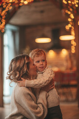 Fototapeta na wymiar Candid authentic happy mom spends time with her cheerful child at wooden lodge Xmas decorated
