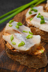 Closeup view of sandwich with salty herring and green onion