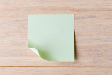 Blank sticky note with copy space on wooden background