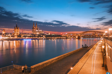 Fototapeta na wymiar Night view of the Rhine embankment in Cologne. Urban life in Germany. Koln Cathedral in the background