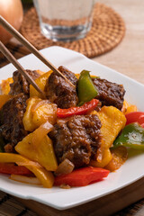 Sweet and sour sauced deep fried pork ribs with chopped pepper and pineapple.