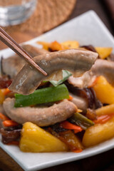 Eating pan-fried pork small intestine with pineapple.