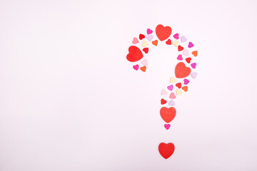 Question symbol made from hearts on a gray background. Marriage proposal symbol. The concept of love and romance. Copy space.