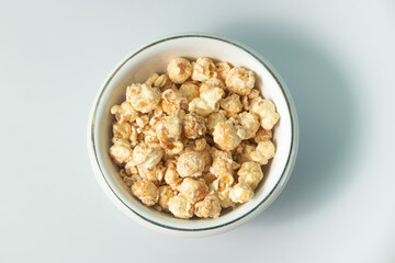 popcorn with butter caramel flavor on a white bowl and white background
