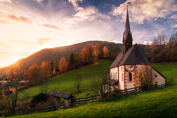 Landscape view at sunset in autumn of the Bad Kleinkirchheim countryside valley, Austrian alps, with the St. Katharina im Bade (St. Kathrein) church on the foreground