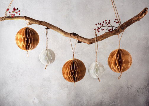 Handmade paper Honeycomb balls hanging on tree branch. Beautiful Christmas decoration foe home. Scandinavian Nordic Craft Paper concept. Selective focus. Copy space.