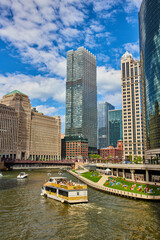 Fototapeta premium Tropical ship sailing through river canals of Chicago surrounded by skyscrapers