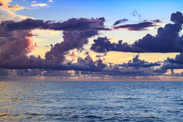 Dark storm clouds background. Dramatic dark clouds sky. Dark cloudy tropical sky at sunset sea background. Stormy cloudy sky.