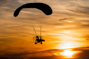 Powered paraglider in sunset - obrazy, fototapety, plakaty