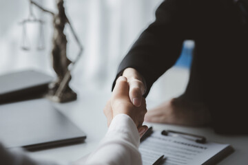 Lawyers shake hands with clients who come to testify in the case of embezzlement from business partners who jointly invest in the business. The concept of hiring a lawyer for legal proceedings.