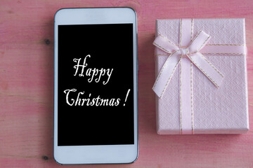 mobile phone and gift box with christmas greeting