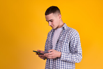 A handsome guy in a checkered shirt on a yellow background