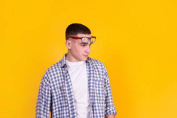 Obraz premium A handsome guy in a checkered shirt on a yellow background
