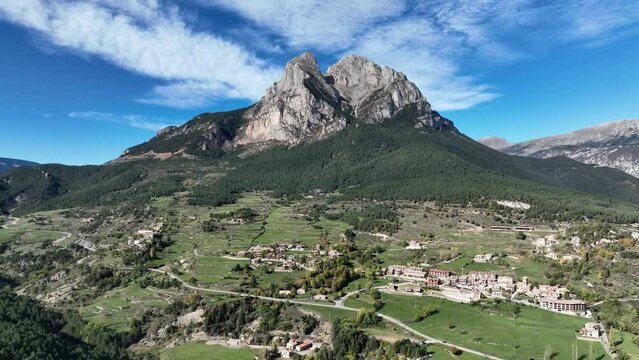 Idyllic Pedraforca stone pitchfork with Saldes village at base of Pyrenees mountain Calralonia wide aerial view