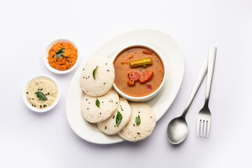 Fototapeta na wymiar Idly sambar or Idli with Sambhar and green, red chutney. Popular South indian breakfast