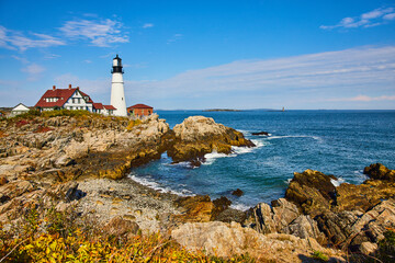 Fototapeta na wymiar Bay with rocky coasts in Maine with overlooking white lighthouse