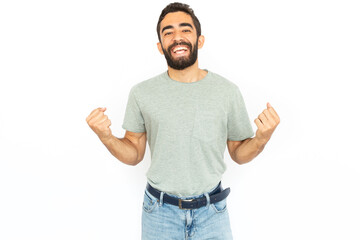 Joyful man with clenched fists. Young male model celebrating victory. Portrait, studio shot, success concept