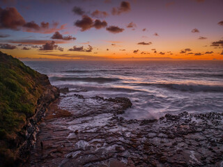 Surfs up sunrise at the seaside with scattered clouds