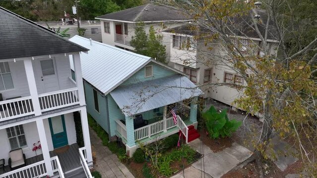 Small bungalow home with American flag in USA. Aerial view of tiny house among southern USA neighborhood.
