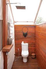 Luxury safari camp bathroom in the middle of the bush in Southern Africa. The bright white interiors are very modern and the tent exterior is dated. These are glamping pods.