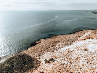 Sea top view from the cliffs of Cyprus. Mediterranean Sea coast. Autumn pale marine landscape.