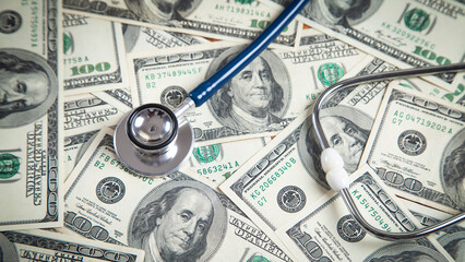Stethoscope on dollar banknotes background.