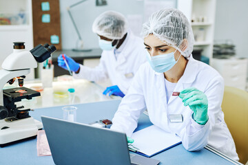 Portrait of young Middle Eastern woman working in modern laboratory and doing blood tests