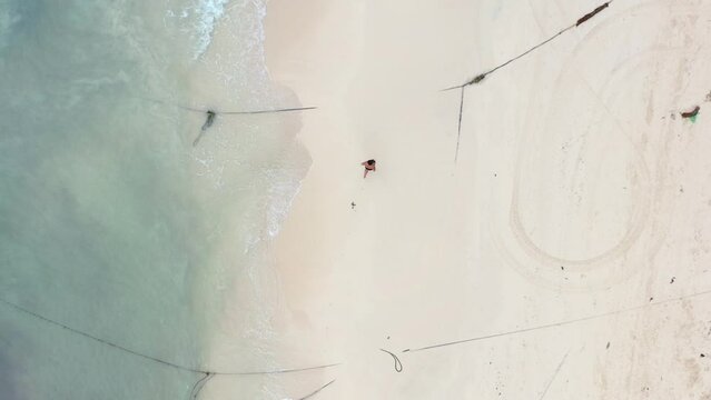 aerial top down of young man running on empty white sand beach in Playa Del Carmen Mexico