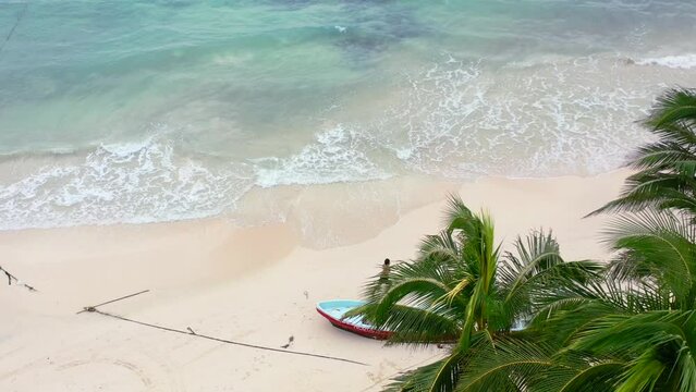 young man running on tropical white sand beach in Mexico on overcast day