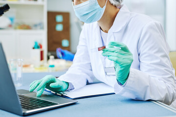 Close up of woman working in modern laboratory and doing blood tests, copy space - obrazy, fototapety, plakaty