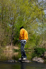 Man standing on a rack in a river