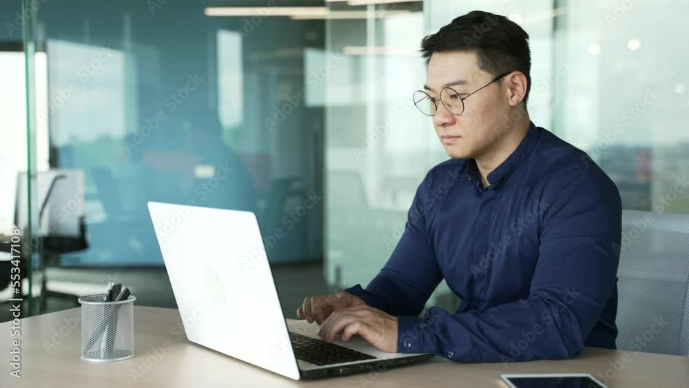 Wall mural busy it specialist programmer with glasses working typing coding on laptop computer in modern office