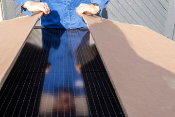 Craftsman opens a package to install new solar panels for new energy generation.