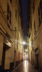 Ruelle très étroite de nuit avec de petits lampadaires dans le Vieux Nice, donnant une impression lugubre ou coupe gorge