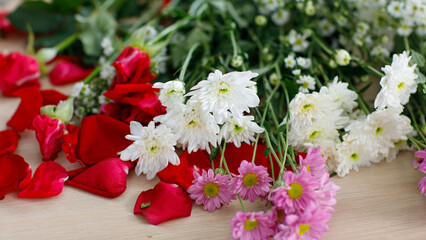 Closeup shot of white pink red petal bunch bouquet flowers placed on workshop table in floral store preparing to arrangement decoration into vase delivery to ordering customer celebrating anniversary