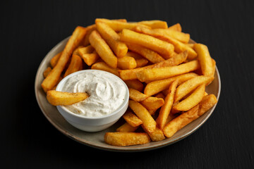 Homemade French Fries with Ranch Dressing on a Plate on a black background, side view.