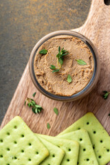 Close up of a jar with homemade liver pate garnished with thyme, overhead shot