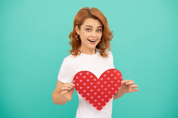 amazed young woman with red heart on blue background