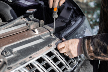Auto repair. installation of a radiator grille diffuser on a car - obrazy, fototapety, plakaty