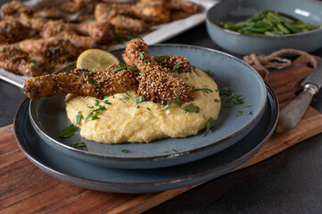 Chicken drumsticks with sesame seeds, polenta and green beans on a plate