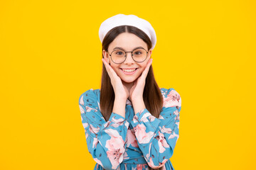 Emotional portrait of caucasian teenager child girl isolated on studio yellow background. Happy teenager, positive and smiling emotions.