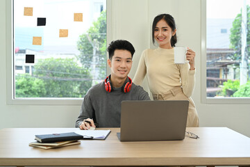 Two young creative people brainstorming, working together for design project at office