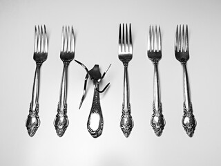 set of silver antique forks with one deformed fork isolated on white background