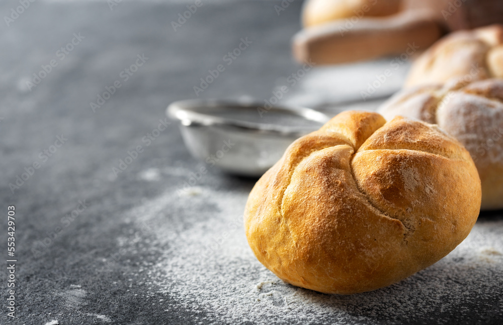 Poster close up of fresh small bun bread on the dark table with copy space. home baking concept
