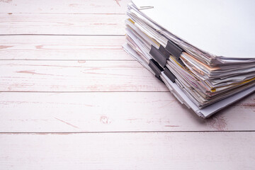 Stack of documents with binder clips on a white wooden table