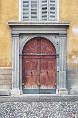 Italian retro wood style front door, the main entrance. Element of the classic Italian facade and architecture