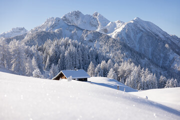 Fototapeta na wymiar Wooden cabin or hut in the mountains in winter in the Austrian Alps.