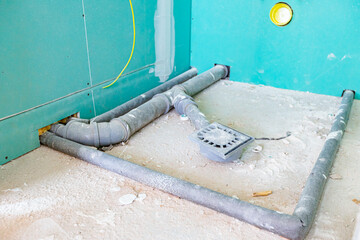 View on installed plastic sewage pipelines placed in the unfinished washroom